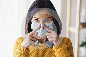 Portrait of young Asian woman,  putting on a medical surgical disposabhttpsle face mask to prevent infection photo
