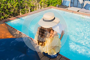 Portrait young asian woman read book around outdoor swimming pool