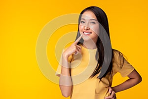 Portrait young asian woman with smile Beautiful girl wear yellow T shirt with yellow background copy space at studio Pretty asia