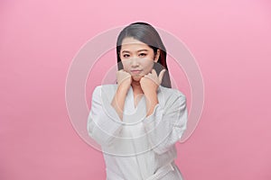 Portrait of young Asian woman smiling friendly with hands on chin