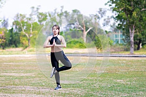 Portrait of a young Asian woman standing and exercising in nature, During the summer or spring time.