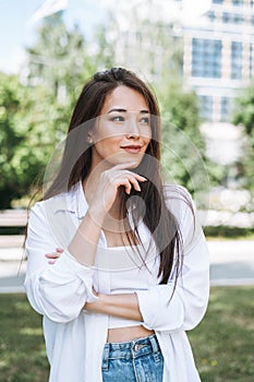 Portrait of young asian woman student with long hair in city park