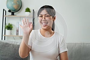 Portrait of young Asian woman wearing eye glasses big smiling and looking at camera with feeling happy and positive in living room