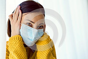 Portrait of young Asian woman,  wearing a medical surgical disposabhttpsle face mask to prevent infection