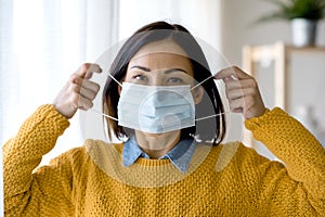 Portrait of young Asian woman,  wearing a medical surgical disposabhttpsle face mask to prevent infection