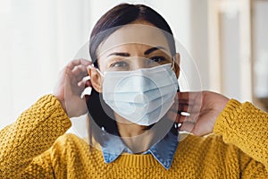 Portrait of young Asian woman,  wearing a medical surgical disposabhttpsle face mask to prevent infection