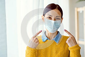 Portrait of young Asian woman,  wearing a medical surgical disposabhttpsle face mask to prevent infection photo