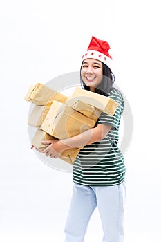 Portrait of a young Asian woman wearing a santa hat and wearing casual clothes lifting a pile of gifts