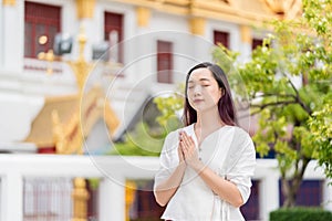 portrait young asian woman wearing traditional dress of Thailand praying