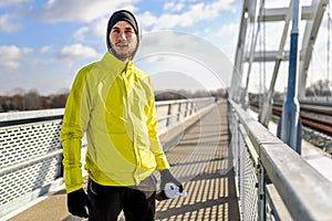 Portrait of young athlete man in windbreaker preparing to exercise