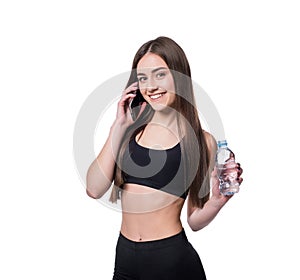 Portrait of a young athlete woman listening to music with earphones over white background. Attractive fitness girl chatting