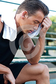 Portrait of a young athletic man with workout towe