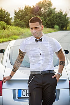 Handsome young man next to car in white shirt