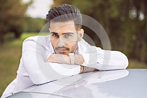 Handsome young man next to car in white shirt