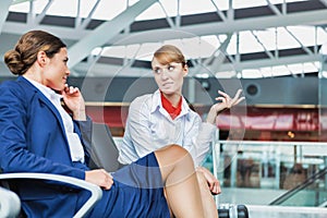 Portrait of young attractive airport staffs talking and sitting while on break in airport photo