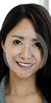 Portrait of young attractive asian creative woman or designer smiling and looking at camera in modern office feeling confident