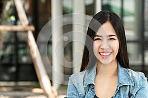 Portrait of young attractive asian woman looking at camera smiling with confident and positive lifestyle concept at outdoor cafe.