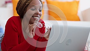 Portrait of young attractive black business woman in glasses having video call on laptop spbi.