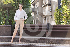 Portrait of a young and attractive Caucasian woman in casual clothes while walking around the city. The concept of fashion, style