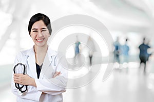 Portrait of young attractive female asian doctor or physician crossed arms holding stethoscope medical equipment