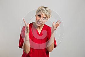 Portrait of young attractive female nurse making explaining gesture