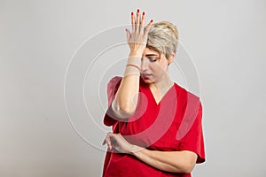 Portrait of young attractive female nurse making mistake gesture