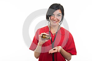 Portrait of young attractive female nurse showing bottle of pills