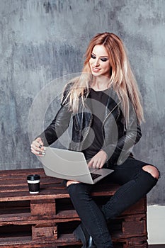 Portrait of young attractive freelancer girl using her laptop computer to send messages and searching information on internet