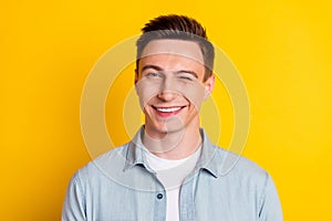 Portrait of young attractive handsome flirty man wink blink eye romance expression isolated on yellow color background