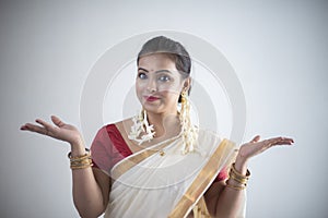 Portrait of an young and attractive Indian woman in white traditional wear for the celebration of Onam/Pongal
