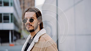 Portrait of young attractive man in casual clothes, wearing sunglasses and posing