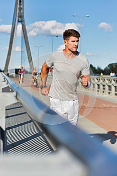 Portrait of young attractive man running in the middle of the city