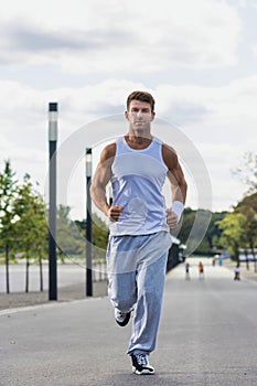 Portrait of young attractive man running in park