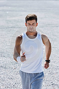 Portrait of young attractive man running in park