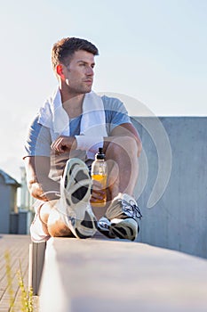 Portrait of young attractive man sitting while drinking energy drink