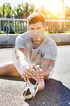 Portrait of young attractive man stretching his legs