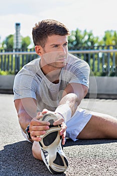 Portrait of young attractive man stretching his legs