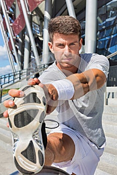 Portrait of young attractive man stretching his legs