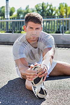 Portrait of young attractive man stretching his legs