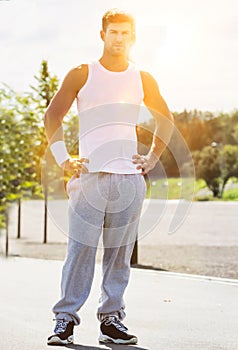 Portrait of young attractive man wearing sports wear standing in park