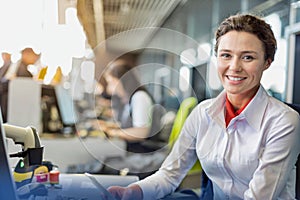 Portrait of young attractive passenger service agent working in airport with lens flare