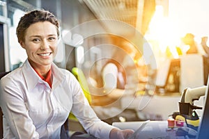 Portrait of young attractive passenger service agent working in airport with lens flare