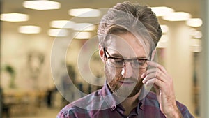Portrait of young attractive serious guy, trying to find an idea how to solve a difficult problem on the background of