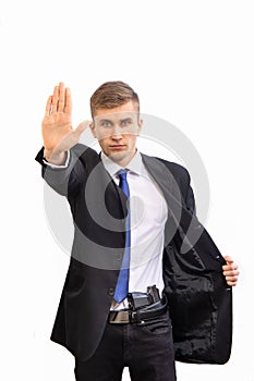 Portrait of young attractive serious security business man with gun in dark suit and bright blue tie, isolated on white