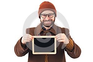 Portrait of a young attractive smiling Caucasian man holding small blackboard brown casual attire isolated studio shot