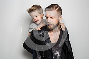 Portrait of young attractive smiling father playing with his little cute son. Fathers day