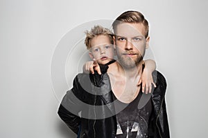 Portrait of young attractive smiling father playing with his little cute son. Fathers day