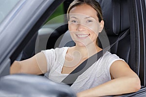 portrait young attractive woman behind wheel in car photo