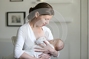 Portrait of a young attractive woman breastfeeding a child