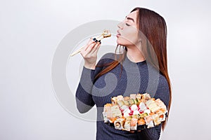 Portrait of young attractive woman eating sushi, studio shoot on